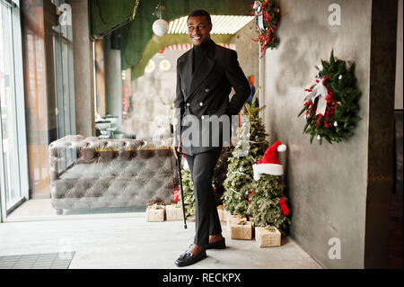 Stilvolle african american Gentleman in elegantem Schwarz Jacke, Holding retro Spazierstock wie Rohr Kolben oder tippling Rohrstock mit golden Diamond ball Griff Stockfoto