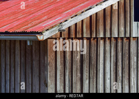 Red Tin Roof auf einem Verwitterten Scheune, Nahaufnahme Stockfoto