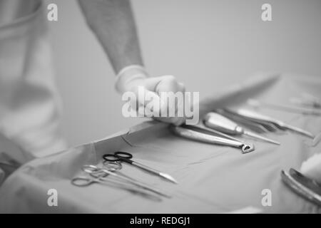 Zahnarzt Arzt Hand in Schutzhandschuh auf einem Tisch mit einem Werkzeug bei der Arbeit Stockfoto