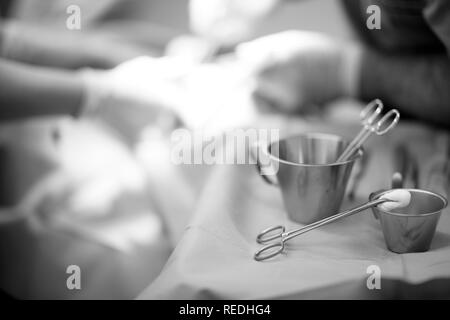 Chirurgische Clips mit Tampons auf den Tisch mit einem Werkzeug in den Operationssaal einer zahnmedizinischen Klinik Stockfoto