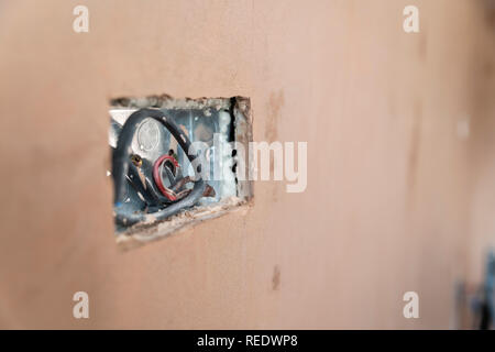 Erste fix inländischen Elektrik in einem frisch Verputzte Wand. Stockfoto