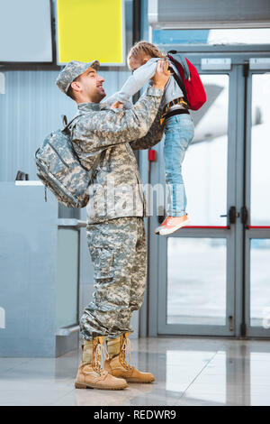 Gerne Vater in Uniform Holding in die Arme süße Tochter im Flughafen Stockfoto