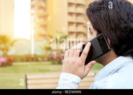 Junger Mann spricht Smartphone. Stockfoto