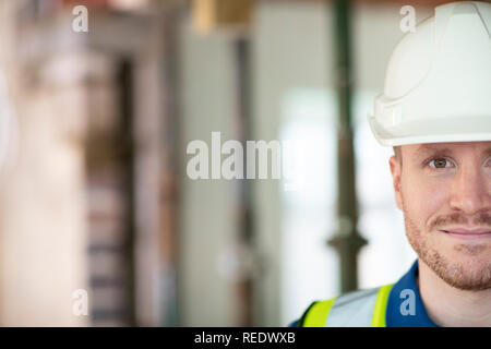 7/8-Portrait von männlichen Bauarbeiter auf der Baustelle tragen Schutzhelm Stockfoto