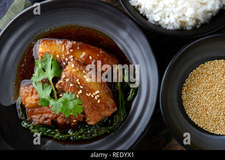 Chinesisch süß gedämpftes Schweinefleisch Einstellung auf Schwarz im japanischen Stil Platte im Studio Beleuchtung. Stockfoto