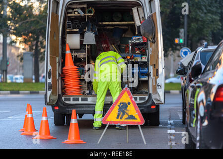 Valencia, Spanien - Januar 16, 2019: Arbeiter in seinem Van, mit Werkzeugen bestückt, vom Verkehr geschützt mit Kegel während der Reparatur eine Ampel in einer c Stockfoto