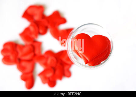 Viele rote Herzen in einem durchsichtigen Glas auf einem weißen Hintergrund. Valentinstag. Herzlichen Glückwunsch zum Valentinstag. Stockfoto