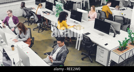 Hohe Betrachtungswinkel von professionellen multiethnischen Geschäftsleute arbeiten mit digitalen Geräten im Büro Stockfoto