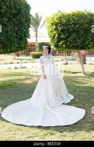 Kleid von Ihr Traum. Tipps und Tricks von Hochzeit im Ausland Experten. Sachen betrachten, Hochzeit im Ausland. Braut adorable White Wedding Dress sonnigen Tag Palm Tree Hintergrund. Hochzeit tropischen Insel. Stockfoto