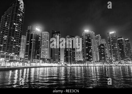 Dubai, Vereinigte Arabische Emirate - Dezember 26, 2017: das Stadtbild von Dubai Marina District in der Nacht. Gebäude mit Licht Reflexion im Wasser. Architektur, Struktur und Design. Reisen und Ferien. Stockfoto