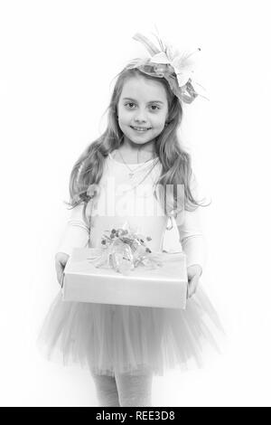 Kind mit Blume im langen blonden Haare isoliert auf Weiss. Mädchen ballerina Lächeln mit Box im rosa Tutu Rock. Vorhanden oder Geschenk geben. Urlaub, Geburtstag, Jubiläum zu feiern. Boxing Day Konzept. Stockfoto