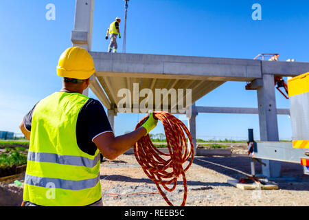 Mitarbeiter sammeln Seil in Bündeln, um die Hand gewickelt. Stockfoto