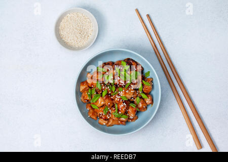 Teriyaki Huhn in einem blauen Platte auf einem hellen Hintergrund. Ansicht von oben Stockfoto