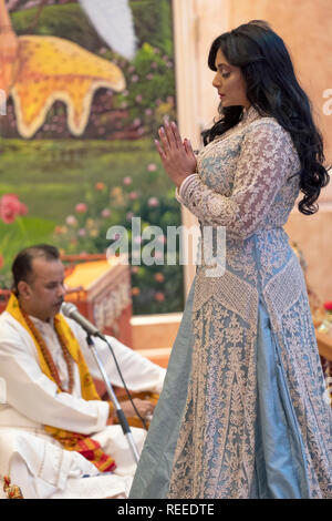 Eine schöne fromme Hindu worshipper feiert ihren Geburtstag durch Unterstützung im Morgengebet Service. In Richmond Hill, Queens, New York City. Stockfoto