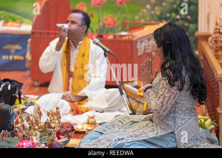 Eine schöne fromme Hindu worshipper feiert ihren Geburtstag durch Unterstützung im Morgengebet Service. In Richmond Hill, Queens, New York City. Stockfoto