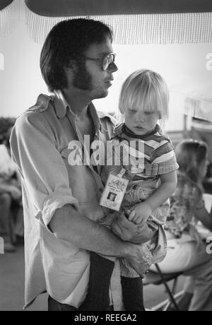 OAKLAND, USA - 14. Juli: Neil Young mit Kind Amber backstage in Oakland, Kalifornien am 14. Juli 1974 während der CROSBY, STILLS, NASH & YOUNG 1974 US Tour (Foto von Gijsbert Hanekroot) aufgeworfen Stockfoto