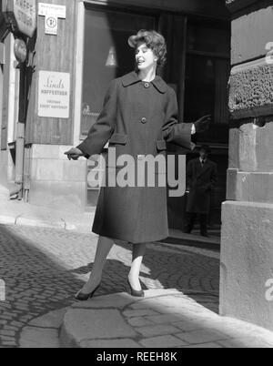 Mode in den 50er Jahren. Eine junge Frau trägt eine typische 50er Mantel. Sie posiert in der Outfit in eine Straße. Schweden 1950. Foto Kristoffersson Ref314 A-5 Stockfoto