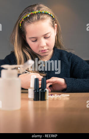 Junge Mädchen für Maniküre zu Hause bereit mit kosmetischen Werkzeuge auf dem Küchentisch Stockfoto