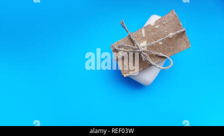 Handgemachte Seife mit Garn auf einem blauen Hintergrund sauber verpackt Stockfoto