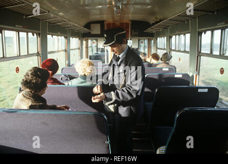 British Rail Diesel Multiple Unit Train Guard und Ticket Collector auf der Cumbrian Coast Railway Line, North West England Stockfoto