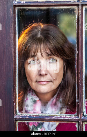 Model Released attraktive, einzelne Frau, schauen aus dem Fenster Stockfoto