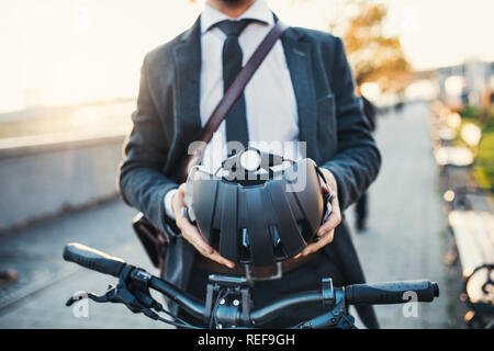 Mittelteil der Geschäftsmann Pendler mit dem Fahrrad unterwegs von der Arbeit in der Stadt. Stockfoto