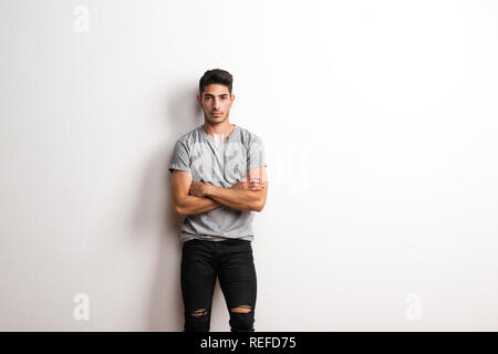 Fröhlicher junger spanischer Mann in einem Studio, Hände, Arme gekreuzt. Kopieren Sie Platz. Stockfoto