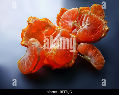 Gebrochene Mandarin, Tangerine Peel. Saftige Scheiben von orange mandarin, sind auf die Schale. Stillleben mit Mandarin Stockfoto