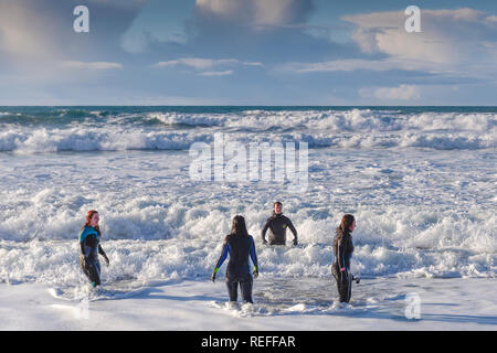 Menschen in Neoprenanzüge im Meer bei Fistral Beach in Newquay Cornwall. Stockfoto