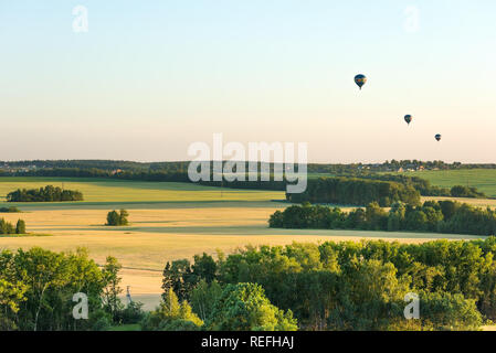 Drei Luftballons fliegen über die Felder Stockfoto