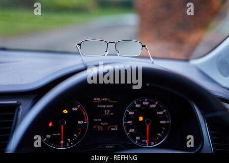 Brille, die auf dem Armaturenbrett des Autos Stockfoto