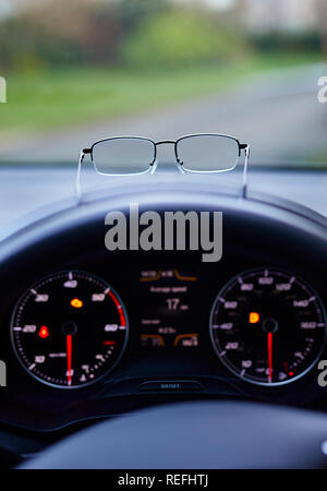 Brille, die auf dem Armaturenbrett des Autos Stockfoto