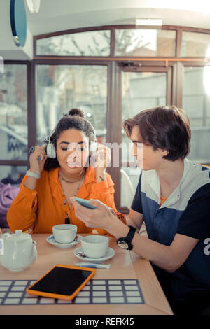 Junge, der seinen Freund Anhören seiner Musik Stockfoto