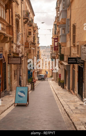 Ein Blick auf St. Lucia Straße. Es handelt sich um einen typischen schmalen Seite Straße mit Geschäften und Wohnungen im Zentrum von Valletta, die Hauptstadt von Malta. Stockfoto