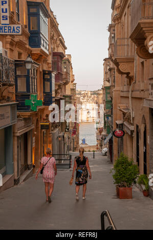 Ein Blick nach unten San Gwann Street (Triq San Gwann). Es handelt sich um einen typischen schmalen Seite Straße mit Geschäften und Wohnungen im Zentrum von Valletta, die von Mauern umgebene Hauptstadt von M Stockfoto