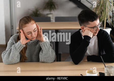 Schlechte Beziehung Konzept. Der Mann und die Frau in der Uneinigkeit. Junges Paar nach Streit sitzen nebeneinander. Im Freien Stockfoto