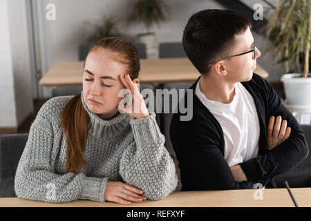 Schlechte Beziehung Konzept. Der Mann und die Frau in der Uneinigkeit. Junges Paar nach Streit sitzen nebeneinander. Im Freien Stockfoto