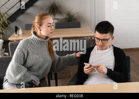 Mädchen vermutet ihr Mann betrügt sie und Spionage Sitzen im Cafe. Misstrauen Konzept Stockfoto