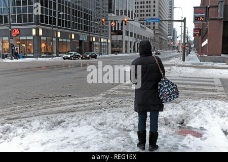 Cleveland, Ohio, USA, 21. Januar 2018. Eine Frau wartet Superior Avenue in der Innenstadt von Cleveland, Ohio, USA zu überqueren, während ihr Gegenüber die Temperatur liest-12c im Festzelt. Credit: Mark Kanning/Alamy Leben Nachrichten. Stockfoto