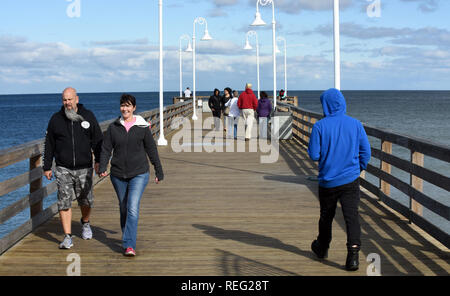 Januar 20, 2019 - Daytona Beach, Florida, United States - Touristen zu Fuß auf der Daytona Beach Pier tragen warme Kleidung wie eine Kaltfront bringt Temperaturen nahe dem Gefrierpunkt in der Nacht zum 20. Januar 2019 in Daytona Beach, Florida. (Paul Hennessy/Alamy) Stockfoto