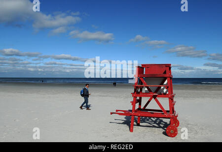 Januar 20, 2019 - Daytona Beach, Florida, United States - ein Mann geht auf einer fast leeren Strand wie eine Kaltfront bringt Temperaturen nahe dem Gefrierpunkt in der Nacht zum 20. Januar 2019 in Daytona Beach, Florida. (Paul Hennessy/Alamy) Stockfoto