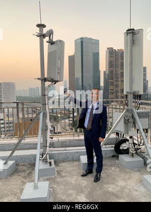 Shenzhen, China. Jan, 2019 21. Ein Mitarbeiter des Chinesischen Mobilfunkanbieter China Telecom zeigt eine Basisstation von Huawei für den neuen 5G-Netz (l) und steht auf dem Dach eines Hochhauses in der Nanshan District neben einem herkömmlichen 4G-station (r). In Shenzhen, wo Huawei auch ihren Sitz hat, gibt es bereits mehrere Hundert 5G-Basisstationen. China ist massiv voran mit dem Ausbau der neuen Mobilfunkstandard, der die Daten transportiert schneller und in grösseren Mengen. Credit: Andreas Landwehr/dpa/Alamy leben Nachrichten Stockfoto