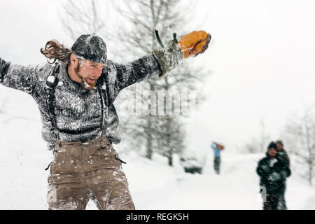 Mitte der erwachsenen Mann mit ausgestreckten Armen in eine winterliche Landschaft. Stockfoto