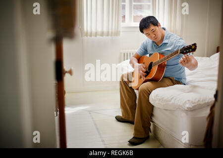 Junge Menschen spielen eine akustische Gitarre. Stockfoto