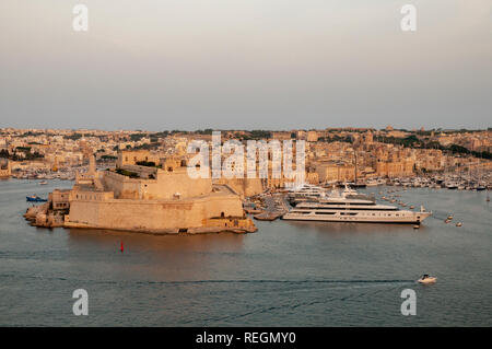 Ansicht vom oberen Barrakka Gärten in Valletta, Malta, über den Grand Harbour und Fort St. Angelo mit Vittoriosa Yacht Marina in der warmen Abendsonne. Stockfoto