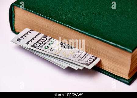 Rechnungen im Wert von 100 US-Dollar im Buch auf einem weißen Hintergrund Makro. Stockfoto