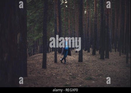 Frau im Herbst dunklen Wald Stockfoto