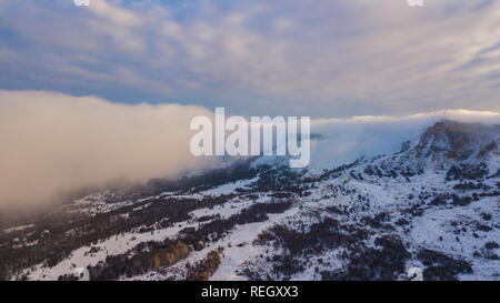 Luftaufnahme auf die schneebedeckten Berge bei Sonnenuntergang Stockfoto