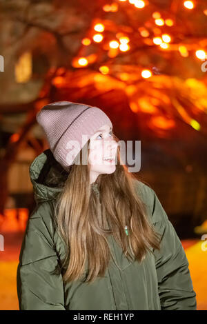 Schöne Mädchen auf den Nacht Stadt Straße vor dem Hintergrund der glühenden Storefront. Hintergrund Mit bokeh. Kopieren Sie Platz für die Beschriftung oder Stockfoto