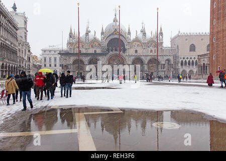 Venedig im Schnee mit Reflexionen von Touristen vor der St. Markus Kathedrale St. Markusplatz, Venedig, Italien Stockfoto